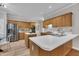 Well-lit kitchen with light wood cabinets, stainless steel appliances, and an island, flowing into a dining area at 206 Wagon Trail Dr, Cary, NC 27513