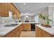 Open concept kitchen with light wood cabinets, white countertops, and appliances, seamlessly connected to the living area at 206 Wagon Trail Dr, Cary, NC 27513