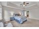 Comfortable main bedroom featuring a tray ceiling, ceiling fan and cozy neutral decor at 206 Wagon Trail Dr, Cary, NC 27513