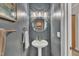 Elegant powder room featuring grey walls, pedestal sink, and decorative mirror at 206 Wagon Trail Dr, Cary, NC 27513