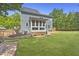 Expansive backyard featuring a well-manicured lawn, screened porch, and stone walkway at 209 Brookberry Rd, Holly Springs, NC 27540