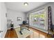Bright bedroom featuring hardwood floors, large window, and a comfortable workspace at 209 Brookberry Rd, Holly Springs, NC 27540