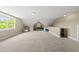 Spacious bonus room with natural light, neutral carpet, and unique architectural details at 209 Brookberry Rd, Holly Springs, NC 27540