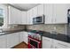 Modern kitchen features white cabinets, stainless steel microwave, and a red gas range at 209 Brookberry Rd, Holly Springs, NC 27540