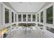 Bright sun room with large windows, tile flooring, and a charming seating area at 209 Brookberry Rd, Holly Springs, NC 27540