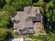 Aerial view of a luxury home with a brick paver patio, a stone fireplace and lush, mature landscaping at 2117 Buckingham Rd, Raleigh, NC 27607