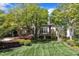A well-manicured lawn and landscaping, mature trees, and a sprawling house with stone accents at 2117 Buckingham Rd, Raleigh, NC 27607