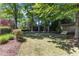 A peaceful backyard with tall trees, mature shrubs, a small storage shed, and an open grassy area at 2117 Buckingham Rd, Raleigh, NC 27607