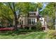 Spacious backyard features stone accents, terrace with railings, arched supports, lush landscaping and mature tree at 2117 Buckingham Rd, Raleigh, NC 27607