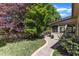 Lush backyard featuring a brick pathway, mature trees, and a screened-in porch at 2117 Buckingham Rd, Raleigh, NC 27607