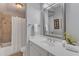 Bathroom featuring a shower-tub combo with tile surround, white vanity, and a large mirror at 2117 Buckingham Rd, Raleigh, NC 27607