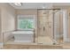 Stylish bathroom featuring a tub, a walk-in shower, travertine tile and neutral walls at 2117 Buckingham Rd, Raleigh, NC 27607