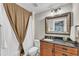Cozy bathroom featuring granite countertop, framed mirror, and decorative shower curtain at 2117 Buckingham Rd, Raleigh, NC 27607