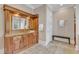 Elegant bathroom boasts a custom vanity, travertine floors and a door to the walk-in closet at 2117 Buckingham Rd, Raleigh, NC 27607