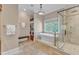 Bright bathroom featuring a soaking tub, a walk-in shower, and a view to the walk-in closet at 2117 Buckingham Rd, Raleigh, NC 27607