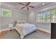 Bright bedroom featuring hardwood floors, star-themed ceiling, and windows with neighborhood views at 2117 Buckingham Rd, Raleigh, NC 27607