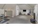 Well-lit home exercise room equipped with weights, TV, and storage, with comfortable carpet flooring at 2117 Buckingham Rd, Raleigh, NC 27607