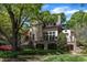 Beautiful home exterior with stone accents, manicured lawn, mature trees, and architectural details at 2117 Buckingham Rd, Raleigh, NC 27607