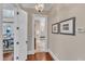 Hallway with hardwood floors leads to a dining space and bathroom with travertine floors at 2117 Buckingham Rd, Raleigh, NC 27607