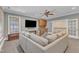 Spacious carpeted living room featuring a flat-screen TV, ceiling fan, and easy access to the staircase at 2117 Buckingham Rd, Raleigh, NC 27607