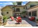 Outdoor patio with stone retaining wall, red patio furniture, and upper story balcony, perfect for outdoor entertaining at 2117 Buckingham Rd, Raleigh, NC 27607