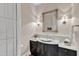 Stylish powder room with a marble countertop, decorative mirror, and elegant lighting fixtures at 2117 Buckingham Rd, Raleigh, NC 27607