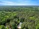 Drone's-eye view showcasing a home among a sea of green trees, reflecting privacy and natural beauty at 2201 Avinshire Pl, Wake Forest, NC 27587