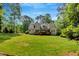 Expansive backyard with lush green lawn and a view of the home's exterior at 2201 Avinshire Pl, Wake Forest, NC 27587