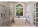 Bright bathroom featuring a soaking tub under a large window with tiled shower and accents at 2201 Avinshire Pl, Wake Forest, NC 27587