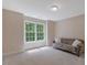 Well-lit bedroom featuring large window and cozy seating area with decorative pillows at 2201 Avinshire Pl, Wake Forest, NC 27587
