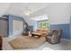 Relaxing bonus room featuring a ceiling fan, neutral carpet, and blue accent walls at 2201 Avinshire Pl, Wake Forest, NC 27587