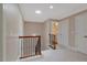 Hallway leading to the bathroom featuring wood railing and white trim at 2201 Avinshire Pl, Wake Forest, NC 27587