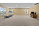 Spacious carpeted bonus room with natural light and a treadmill at 244 N Prince Henry Way, Cameron, NC 28326