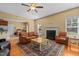 Comfortable living room with fireplace, ceiling fan, and natural light showcasing a classic rug and hardwood floors at 244 N Prince Henry Way, Cameron, NC 28326