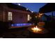 Nighttime view of backyard oasis with hot tub, fire pit, and string lights creating a cozy and inviting atmosphere at 2637 Forestbluff Dr, Fuquay Varina, NC 27526