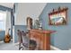 Charming bar area featuring a classic wooden bar, barstools, and a stylish display shelf for drinks and glassware at 2637 Forestbluff Dr, Fuquay Varina, NC 27526