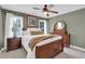 Comfortable bedroom featuring wood furniture, soft bedding, two windows, and a ceiling fan at 2637 Forestbluff Dr, Fuquay Varina, NC 27526
