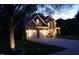 Elegant brick home featuring a two-car garage and a well-manicured lawn, illuminated at dusk at 2637 Forestbluff Dr, Fuquay Varina, NC 27526
