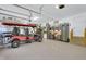 Well-lit garage featuring epoxy floors, storage cabinets, and golf cart parking at 2637 Forestbluff Dr, Fuquay Varina, NC 27526