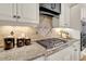 Gourmet kitchen with stainless steel gas range, custom backsplash, and granite countertops at 2637 Forestbluff Dr, Fuquay Varina, NC 27526