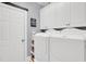 Bright laundry room with white cabinets, washer, dryer and folding space at 2637 Forestbluff Dr, Fuquay Varina, NC 27526