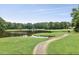 Scenic pond with walking path, surrounded by lush trees and greenery at 2637 Forestbluff Dr, Fuquay Varina, NC 27526