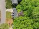 An aerial view displays a home nestled among mature trees in a quiet neighborhood showcasing its peaceful and private setting at 2908 Bolo Trl, Raleigh, NC 27615