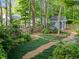 Backyard featuring a charming shed, lush greenery, and stone pathways, creating a serene and inviting outdoor space at 2908 Bolo Trl, Raleigh, NC 27615