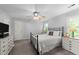 A cozy bedroom with neutral decor, includes a metal frame bed, ceiling fan, and dresser for storage at 2908 Bolo Trl, Raleigh, NC 27615