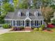 Charming blue two-story home with well-manicured lawn, lush landscaping, and black shutters at 2908 Bolo Trl, Raleigh, NC 27615