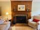 Close up of a wood-burning fireplace with decorative mantel, brick hearth, and hearth tools at 2908 Bolo Trl, Raleigh, NC 27615