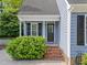 Cozy side entrance with brick steps, black door, and lush green shrubbery at 2908 Bolo Trl, Raleigh, NC 27615