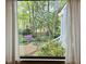 Inviting window view of backyard garden with mature trees and flowering bushes creates a tranquil scene at 2908 Bolo Trl, Raleigh, NC 27615