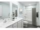 Bright bathroom with double vanity, framed mirror, shower-tub combo and neutral-toned decor at 294 N Coral Bells Way, Four Oaks, NC 27524